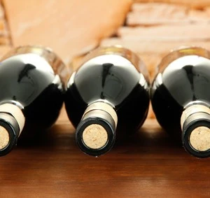 Wine bottles on wooden table, on stone background